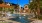a swimming pool with palm trees and apartment building in the background