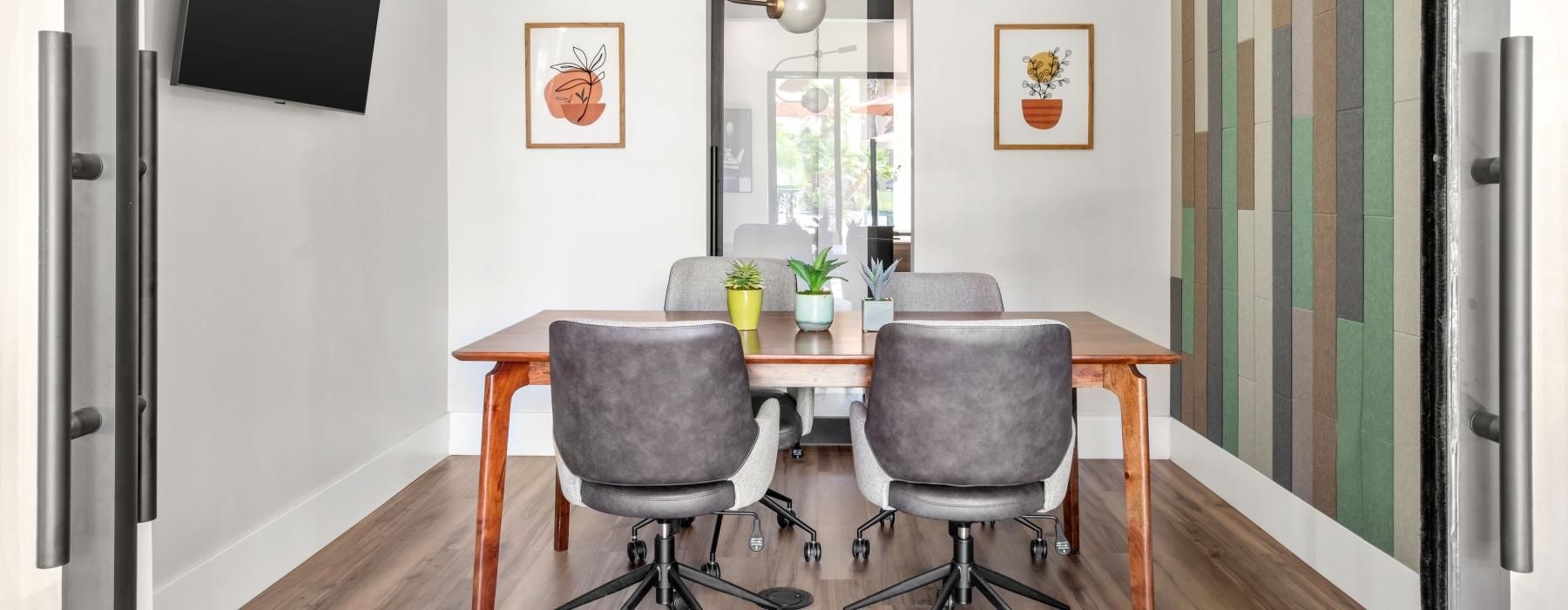 a private room with table, chairs and mounted tv 