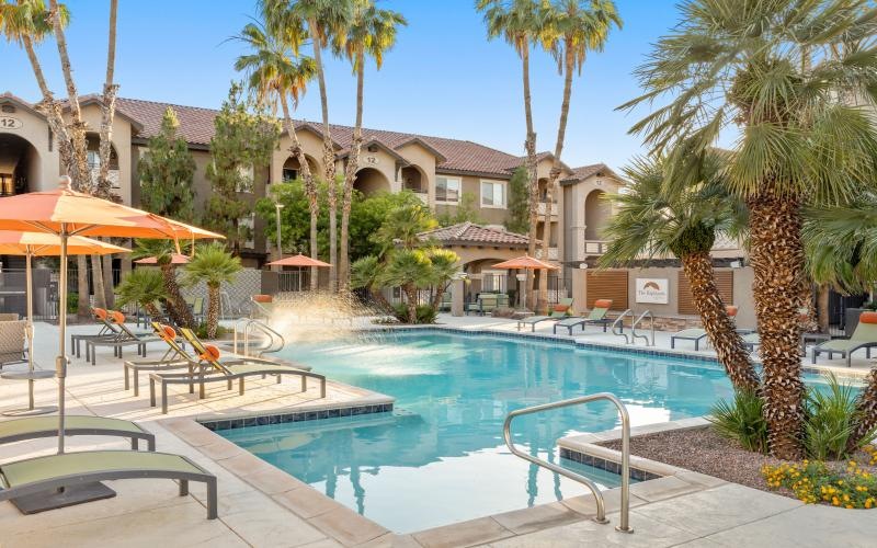 a pool with apartment building in the background